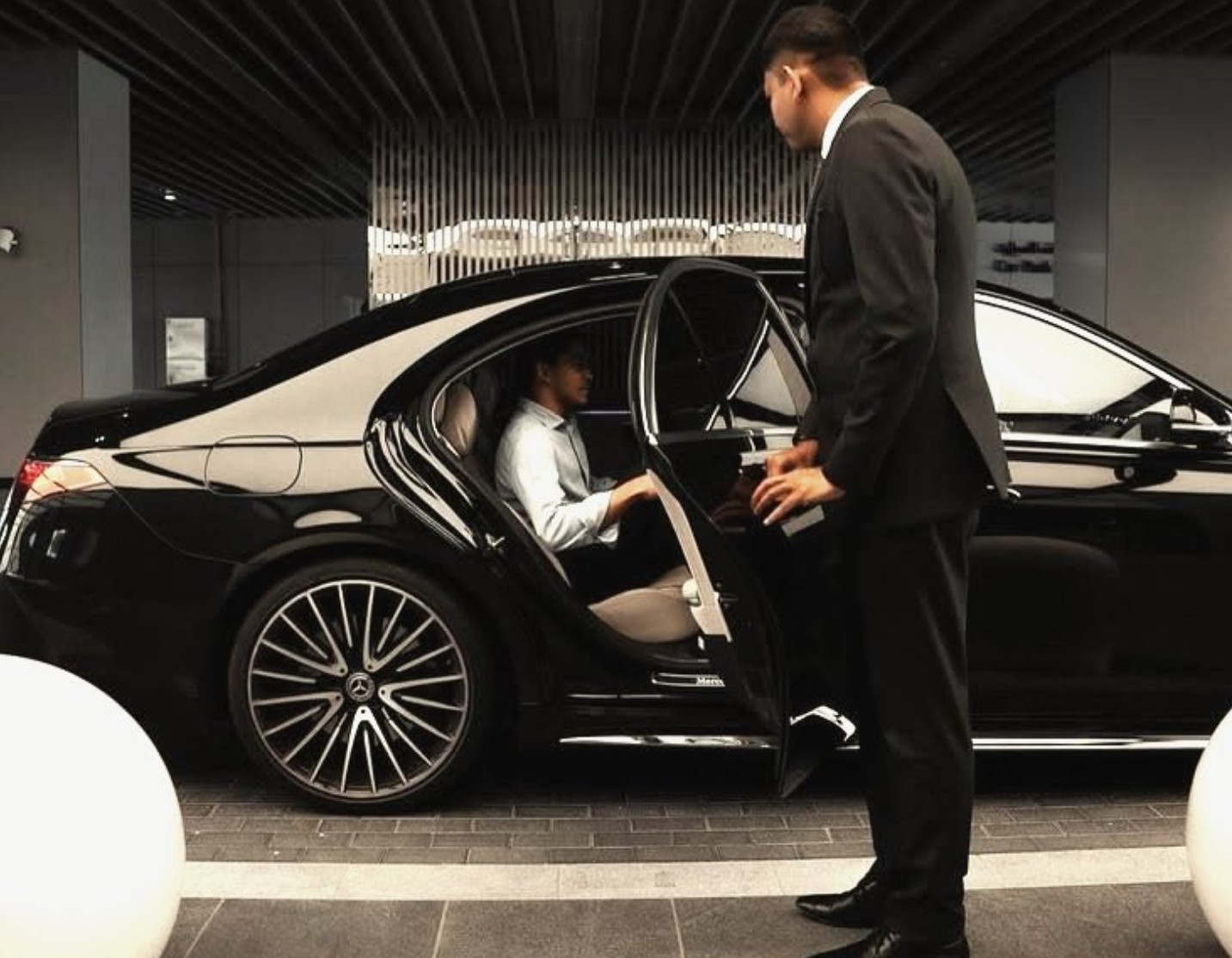 A chauffeur opening the door of a member's car