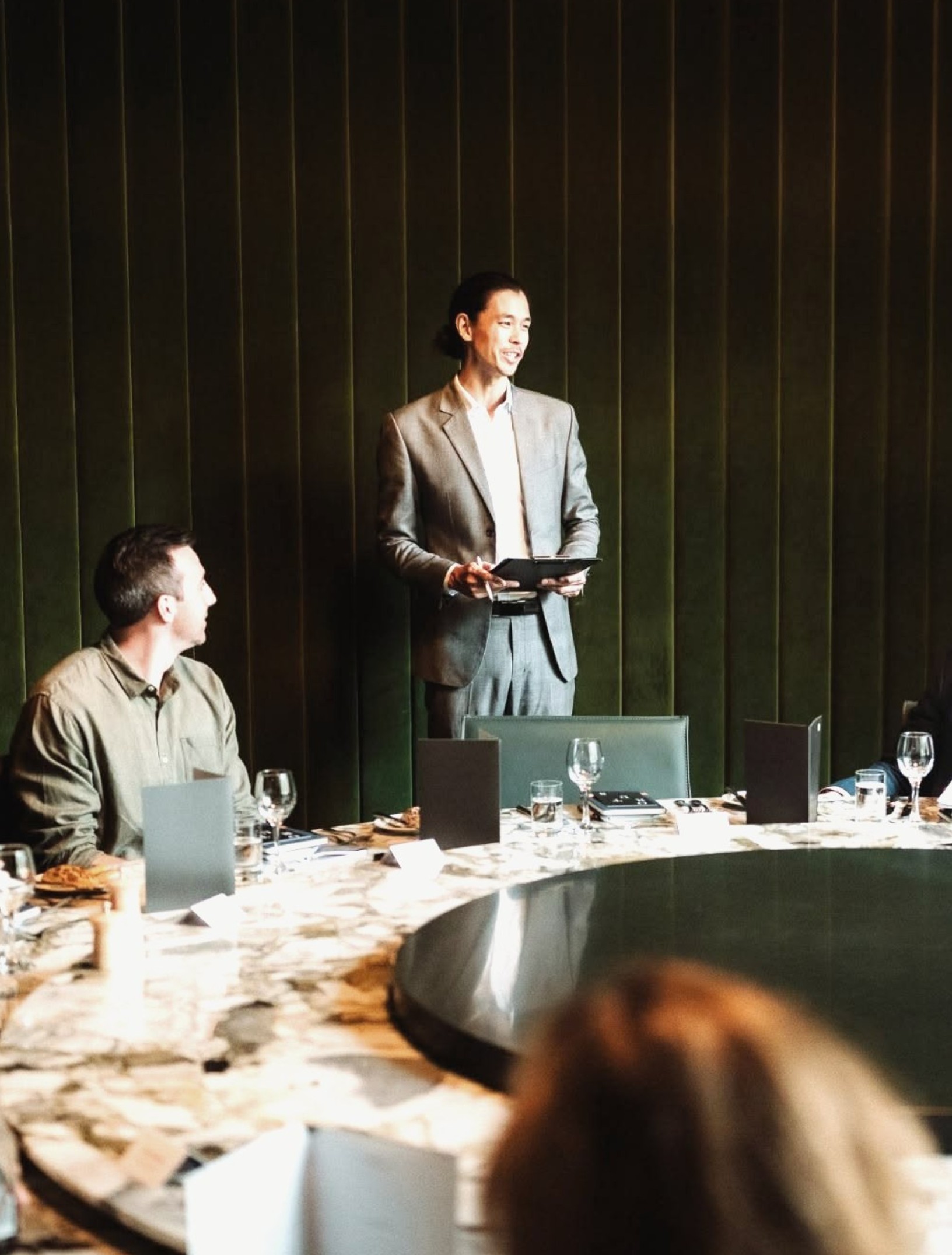 A host addressing members at a round table